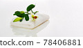 a white lily bud with green leaves on a white towel. Spa concept 78406881