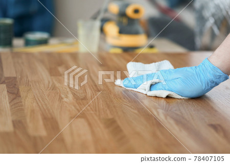 Apply wood care oil to product closeup 78407105