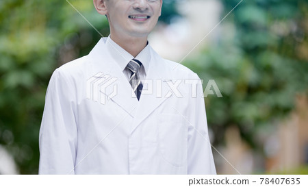 Doctor standing against a tree Doctor standing against a tree 78407635