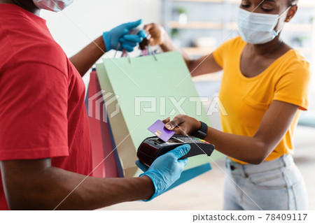 Black Female Paying With Credit Card Receiving Bags From Courier Black Female Paying With Credit Card Receiving Bags From Courier 78409117
