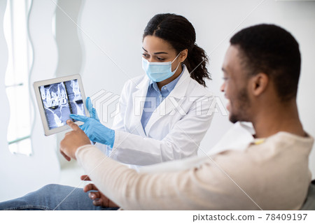 Black Female Dentist Showing Male Patient Teeth Xray Picture On Digital Tablet 78409197