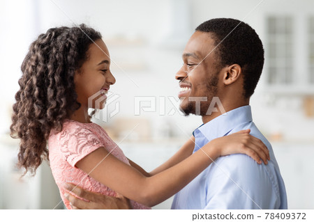 Black little girl and father hugging, looking at each other 78409372