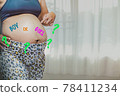 Young asian pregnant attractive woman, standing by the window, Pregnant woman with a sticky note and writing love boy or girl on her belly. Pregnant woman with question on sticker. 78411234