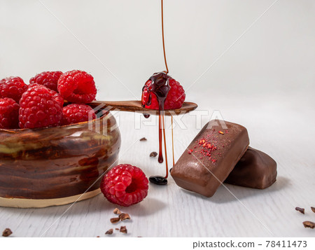 Dark handmade chocolate with raspberries and syrup Dark handmade chocolate with raspberries and syrup 78411473