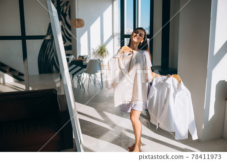 Beautiful girl trying dress in room 78411973