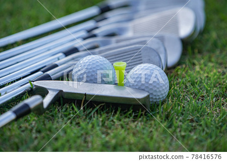 Golf ball and golf club on green grass background. 78416576