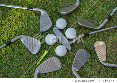Golf ball and golf club on green grass background. 78416577