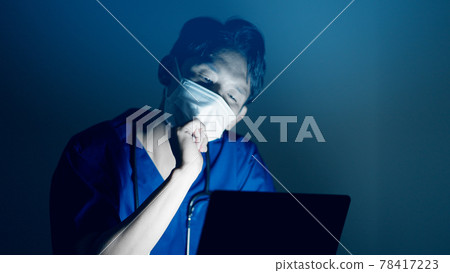 Doctor looking at a laptop at the hospital at night Doctor looking at a laptop at the hospital at night 78417223