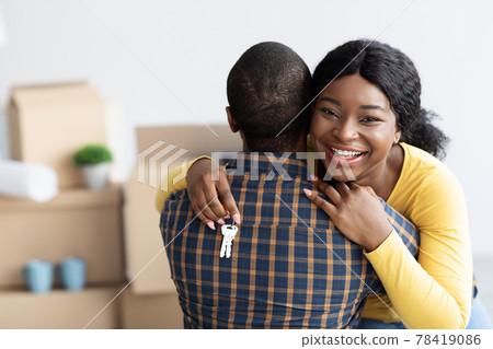 Own House. Happy Black Woman Holding Home Keys And Embracing Husband Own House. Happy Black Woman Holding Home Keys And Embracing Husband 78419086