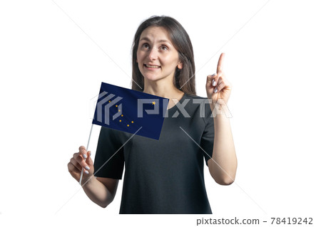 Happy young white woman holding flag of Alaska and points thumbs up isolated on a white background 78419242