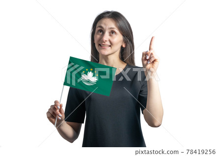 Happy young white woman holding flag of Macau and points thumbs up isolated on a white background 78419256