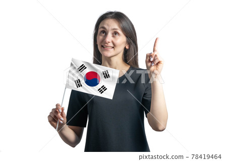 Happy young white woman holding flag of South Korea and points thumbs up isolated on a white background 78419464