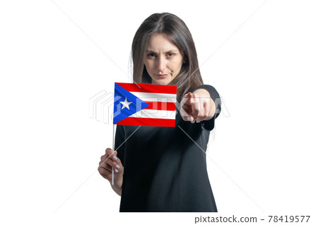 Happy young white woman holding flag of Puerto Rico and points forward in front of him isolated on a white background Happy young white woman holding flag of Puerto Rico and points forward in front of him isolated on a white background 78419577