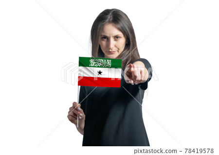 Happy young white woman holding flag of Somaliland and points forward in front of him isolated on a white background Happy young white woman holding flag of Somaliland and points forward in front of him isolated on a white background 78419578