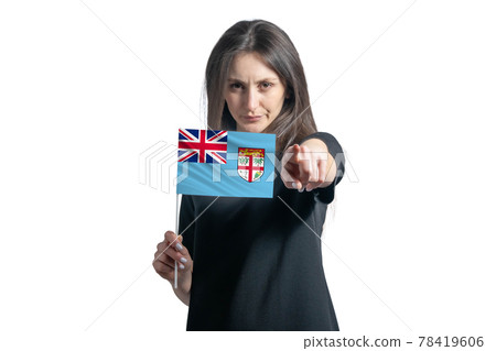 Happy young white woman holding flag of Fiji and points forward in front of him isolated on a white background Happy young white woman holding flag of Fiji and points forward in front of him isolated on a white background 78419606