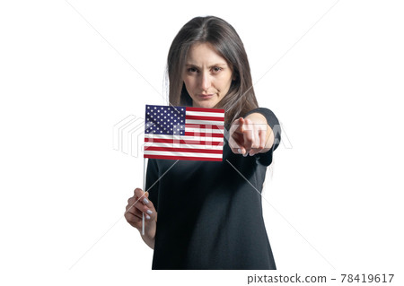 Happy young white woman holding flag of United States and points forward in front of him isolated on a white background Happy young white woman holding flag of United States and points forward in front of him isolated on a white background 78419617