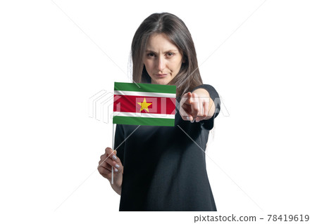 Happy young white woman holding flag of Suriname and points forward in front of him isolated on a white background Happy young white woman holding flag of Suriname and points forward in front of him isolated on a white background 78419619