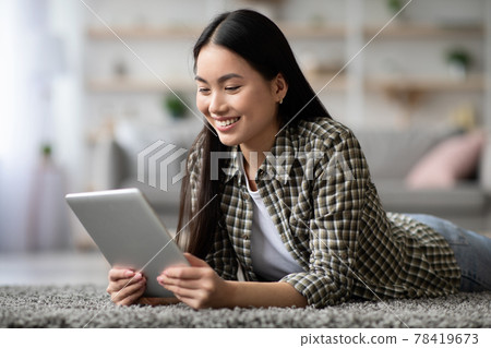 Positive asian woman surfing on social media, using digital tablet 78419673
