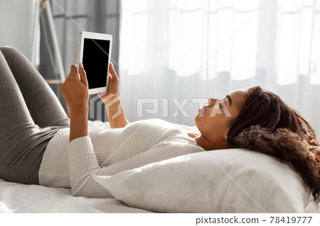 African American person holding tablet with blank empty screen African American person holding tablet with blank empty screen 78419777