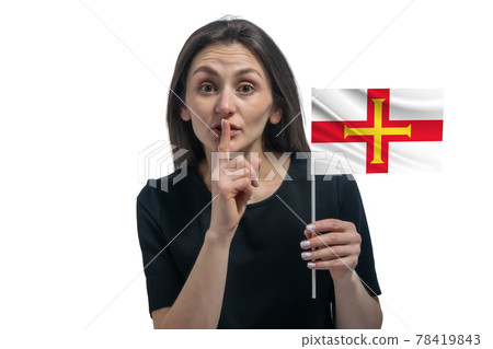 Happy young white woman holding flag of Guernsey and holds a finger to her lips isolated on a white background 78419843