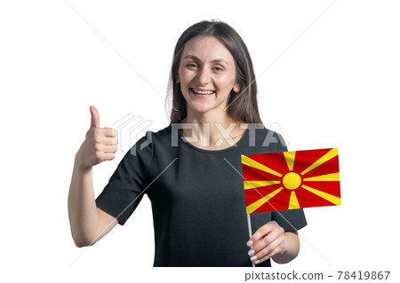 Happy young white woman holding flag of Northern Macedonia and shows the class by hand isolated on a white background 78419867