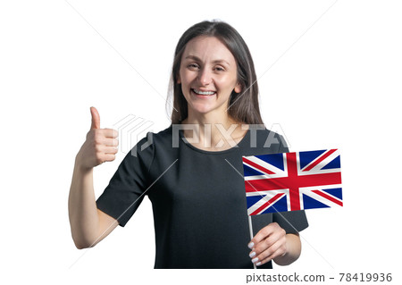 Happy young white woman holding flag of United Kingdom and shows the class by hand isolated on a white background 78419936
