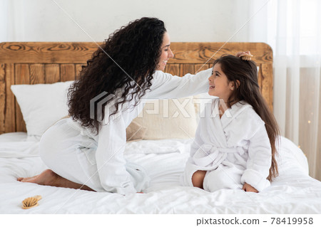 Loving mother brushing her little daughter long hair 78419958