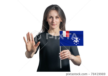 Happy young white woman holding flag of French Southern and Antarctic Territories and with a serious face shows a hand stop sign isolated on a white background 78419989