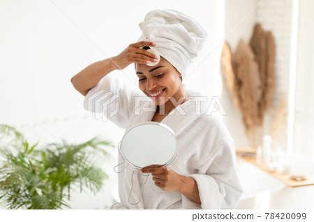 Black Lady Removing Makeup With Cotton Pad In Bathroom Black Lady Removing Makeup With Cotton Pad In Bathroom 78420099