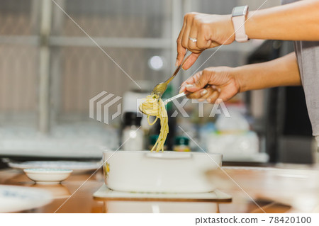 Woman eating creamy spaghetti carbonara with folk and spoon at dinner table. Woman eating creamy spaghetti carbonara with folk and spoon at dinner table. 78420100