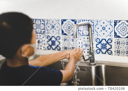 Asian little boy hand washing with tap water in kitchen sink during covid-19. Asian little boy hand washing with tap water in kitchen sink during covid-19. 78420106