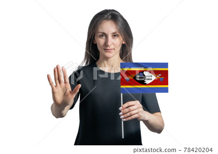 Happy young white woman holding flag of Esvatini and with a serious face shows a hand stop sign isolated on a white background 78420204