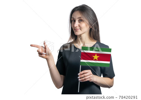 Happy young white woman holding flag Suriname and points to the left isolated on a white background 78420291