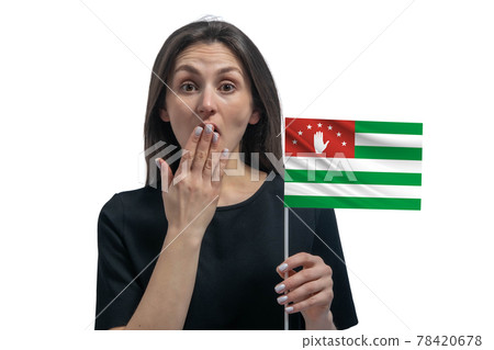 Happy young white woman holding flag of Abkhazia and covers her mouth with her hand isolated on a white background Happy young white woman holding flag of Abkhazia and covers her mouth with her hand isolated on a white background 78420678