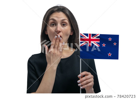 Happy young white woman holding flag of New Zealand and covers her mouth with her hand isolated on a white background 78420723