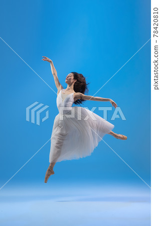 Young and graceful ballet dancer isolated on blue studio background. Art, motion, action, flexibility, inspiration concept. 78420810