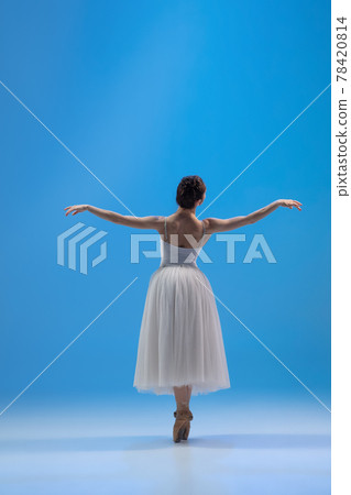 Young and incredibly beautiful ballerina is posing and dancing at blue studio full of light. Young and incredibly beautiful ballerina is posing and dancing at blue studio full of light. 78420814