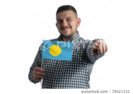 White guy holding a flag of Palau and points forward in front of him isolated on a white background White guy holding a flag of Palau and points forward in front of him isolated on a white background 78421152