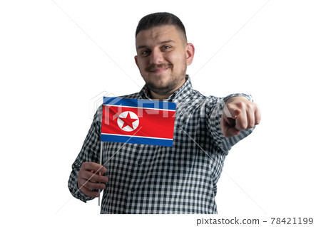 White guy holding a flag of North Korea and points forward in front of him isolated on a white background 78421199