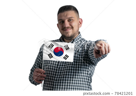 White guy holding a flag of South Korea and points forward in front of him isolated on a white background 78421201