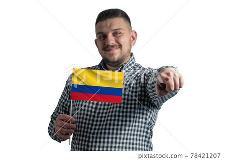 White guy holding a flag of Colombia and points forward in front of him isolated on a white background White guy holding a flag of Colombia and points forward in front of him isolated on a white background 78421207
