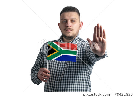 White guy holding a flag of South African Republic and with a serious face shows a hand stop sign isolated on a white background White guy holding a flag of South African Republic and with a serious face shows a hand stop sign isolated on a white background 78421856