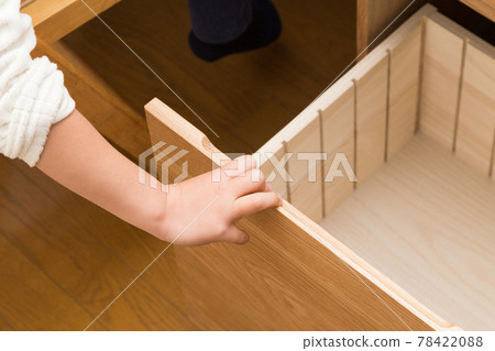 Child opening a desk drawer 78422088