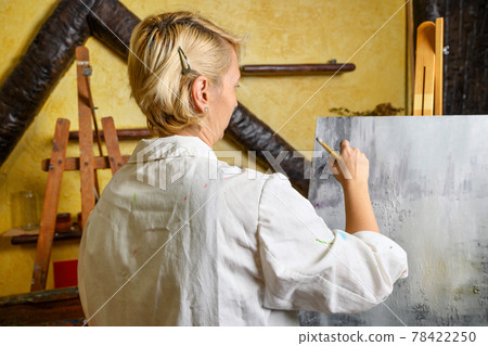 Woman having fun painting in art class Woman having fun painting in art class 78422250