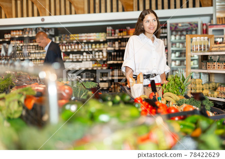 Portrait of a happy girl with a grocery cart in the supermarket 78422629