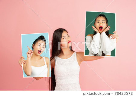 Young girl holding her portraits isolated over studio background with copyspace for ad. Concept of beauty, fashion. 78423578