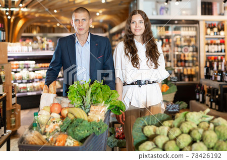 Portrait of a confident young couple with a grocery cart in the supermarket 78426192