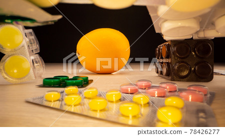 Coloured pills in plastic blisters surround fresh orange Coloured pills in plastic blisters surround fresh orange 78426277