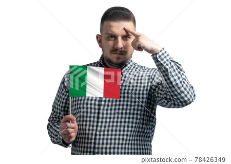 White guy holding a flag of Italy and a finger touches the temple on the head isolated on a white background White guy holding a flag of Italy and a finger touches the temple on the head isolated on a white background 78426349