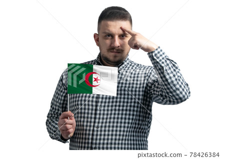 White guy holding a flag of Algeria and a finger touches the temple on the head isolated on a white background 78426384